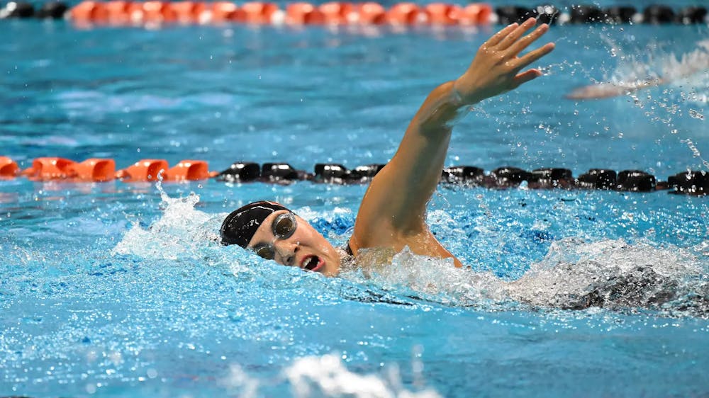 Women in black Princeton cap swimming in pool,