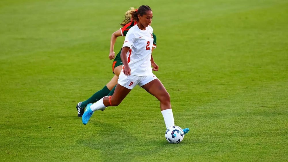 Girl in white jersey gets ready to kick soccer ball.