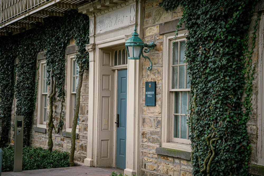 The facade of an ivy-covered building with a blue door.