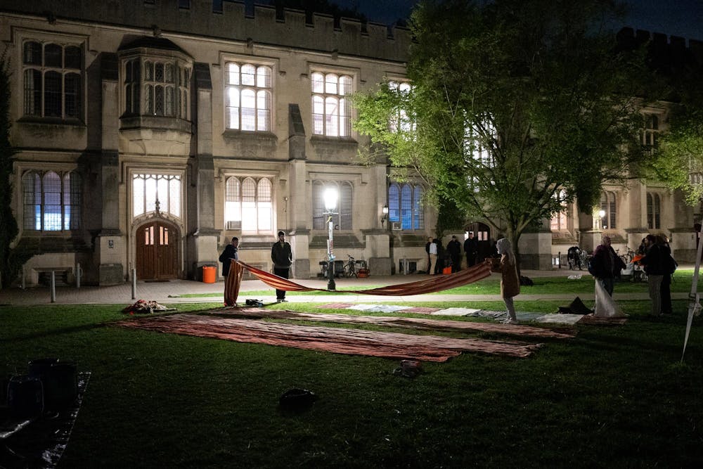 <h5>Organizers set up prayer rugs in anticipation of the Isha evening prayer.</h5><h6>Calvin Grover / The Daily Princetonian</h6><p><br></p>