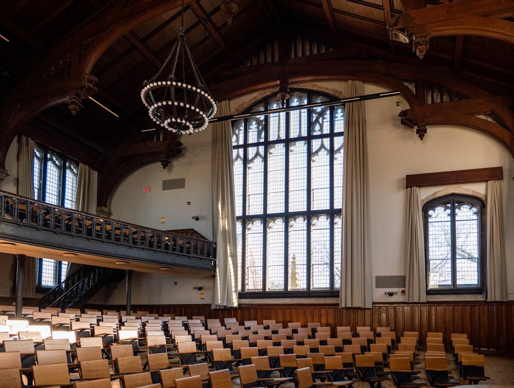 A photo of a lecture hall, with balcony seating and large gothic windows.