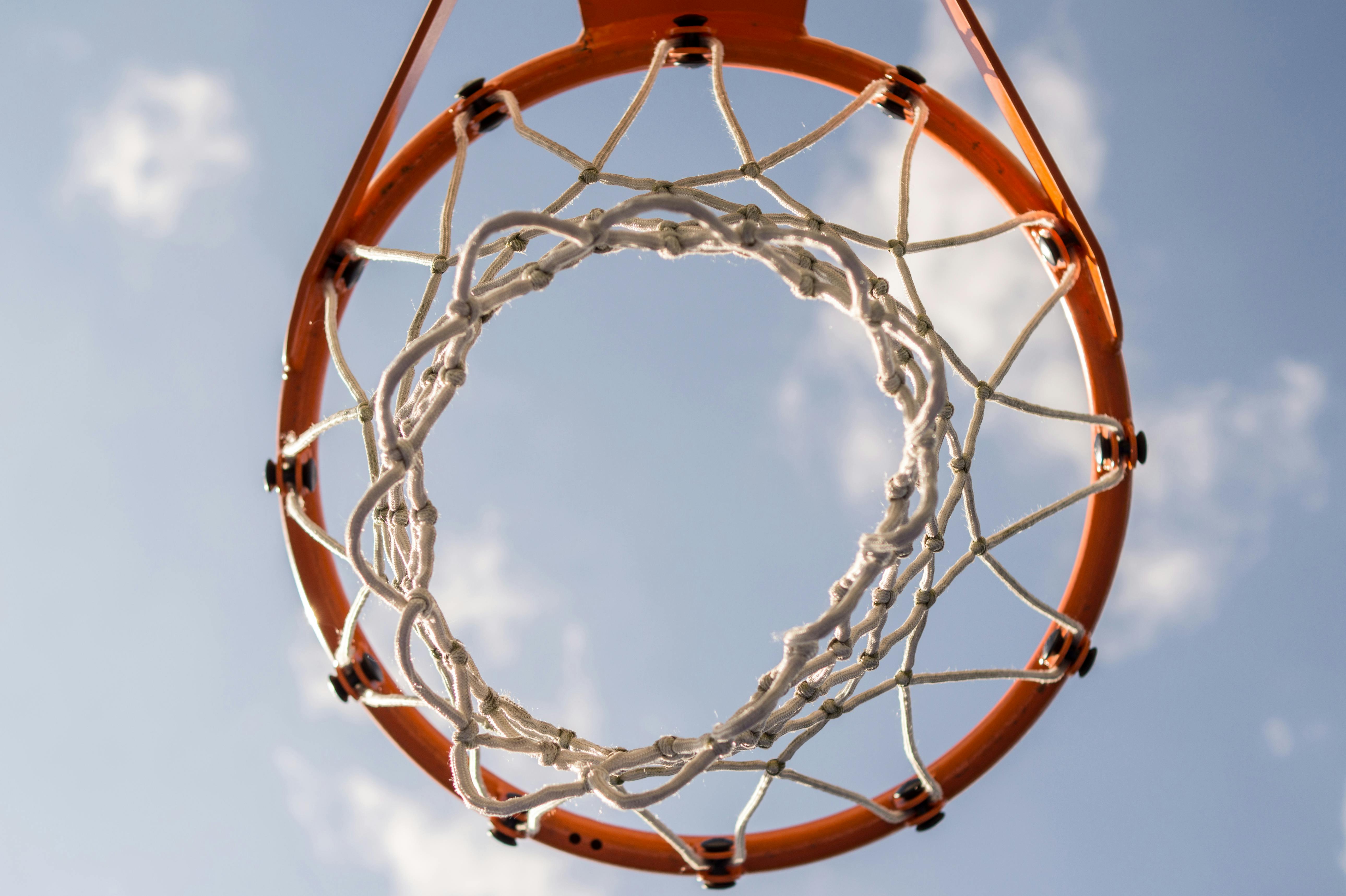 Basketball hoop and net from below.