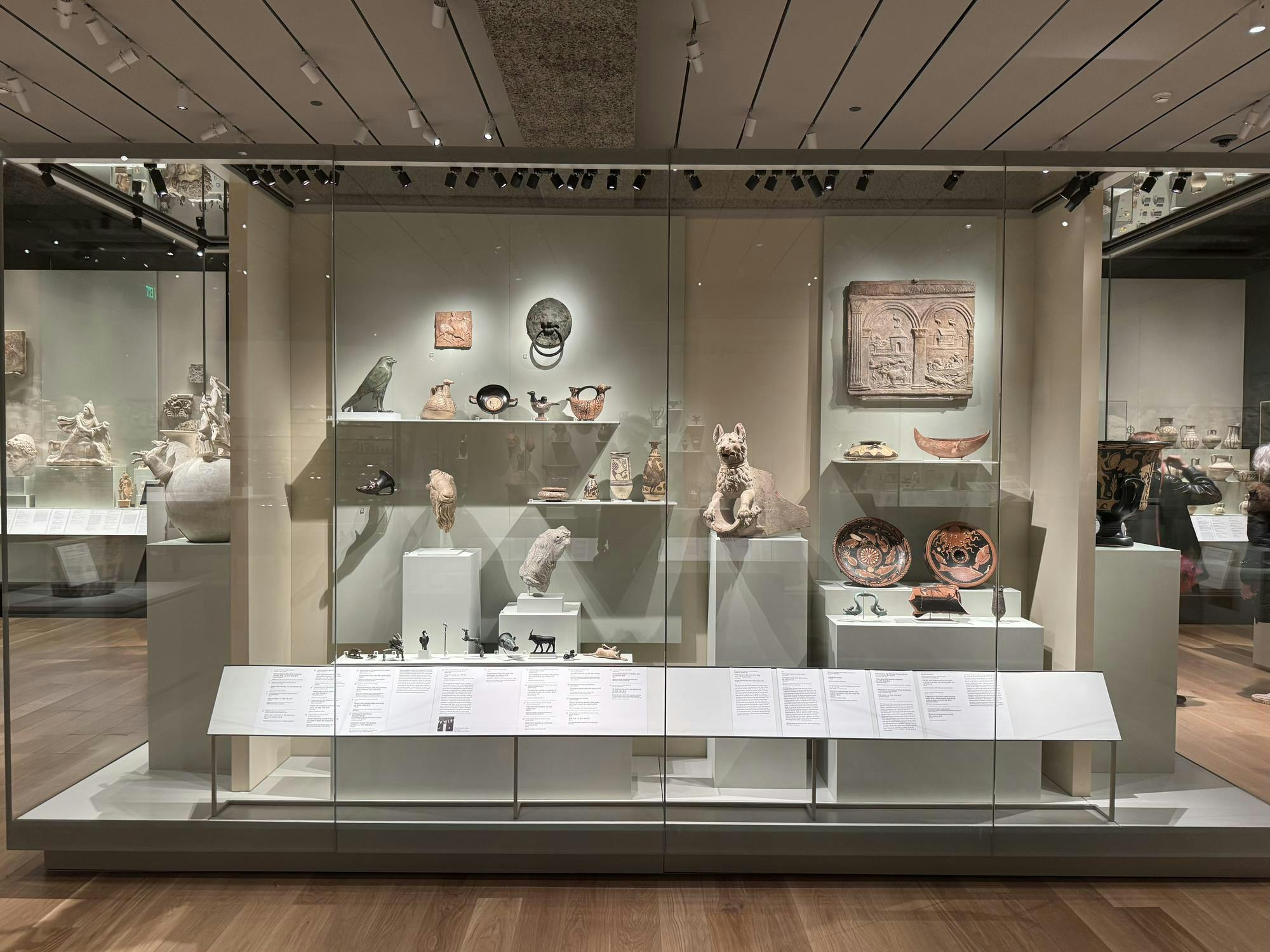 A case of ancient artwork such as bowls and animal statues.