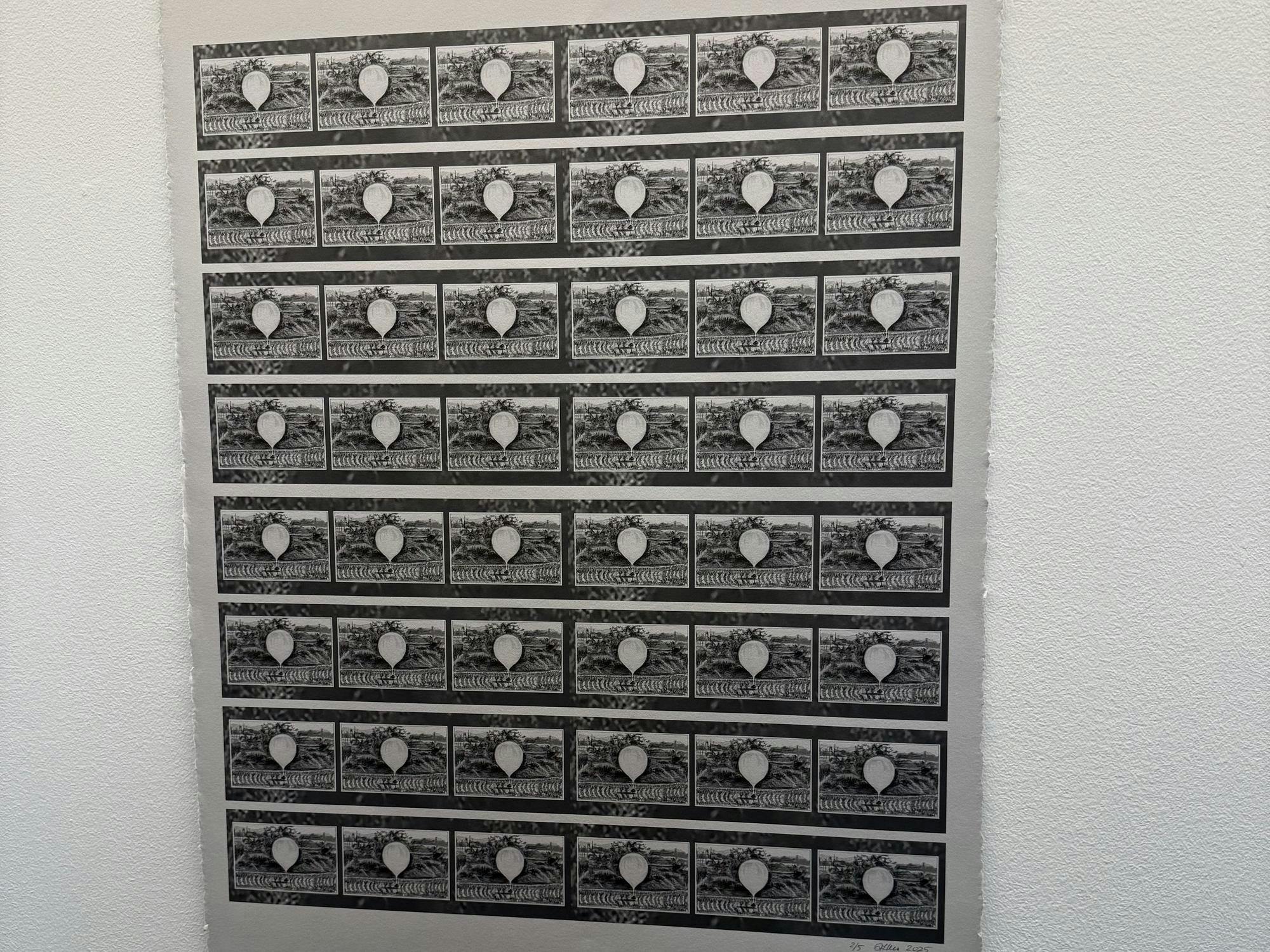 A black and white print is against a white wall.