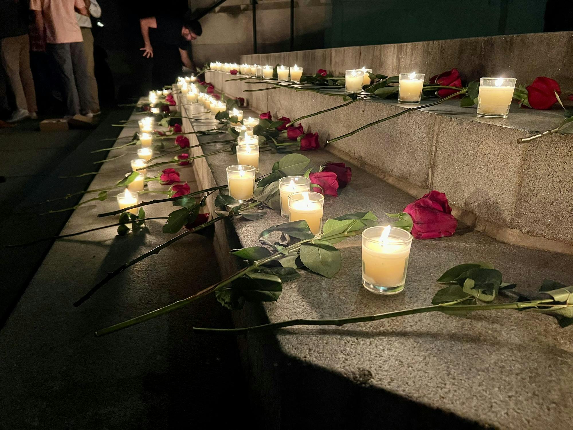 Red roses and lit candles on the University chapel's front steps.
