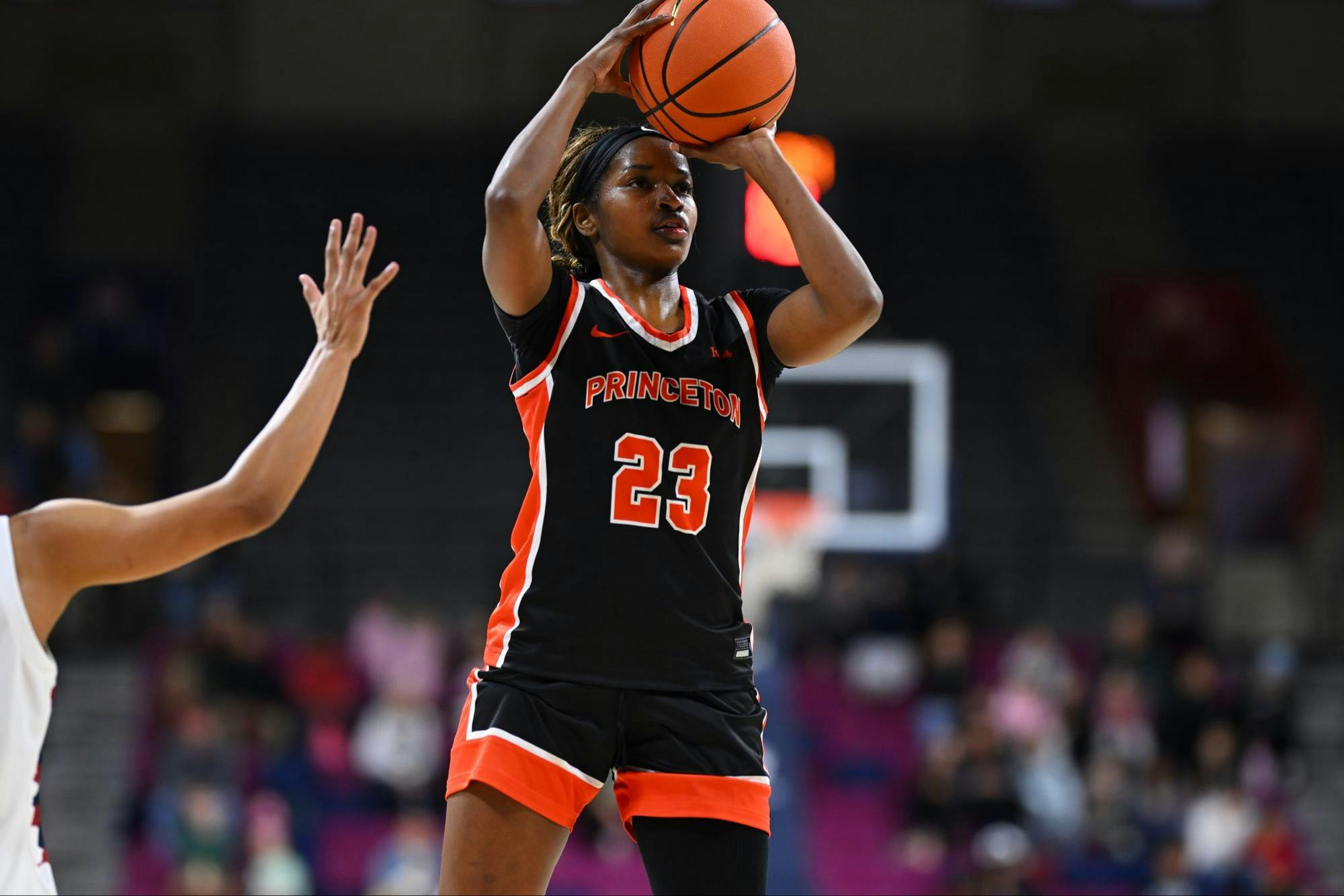 Princeton woman basketball player in black jersey shooting a basketball.