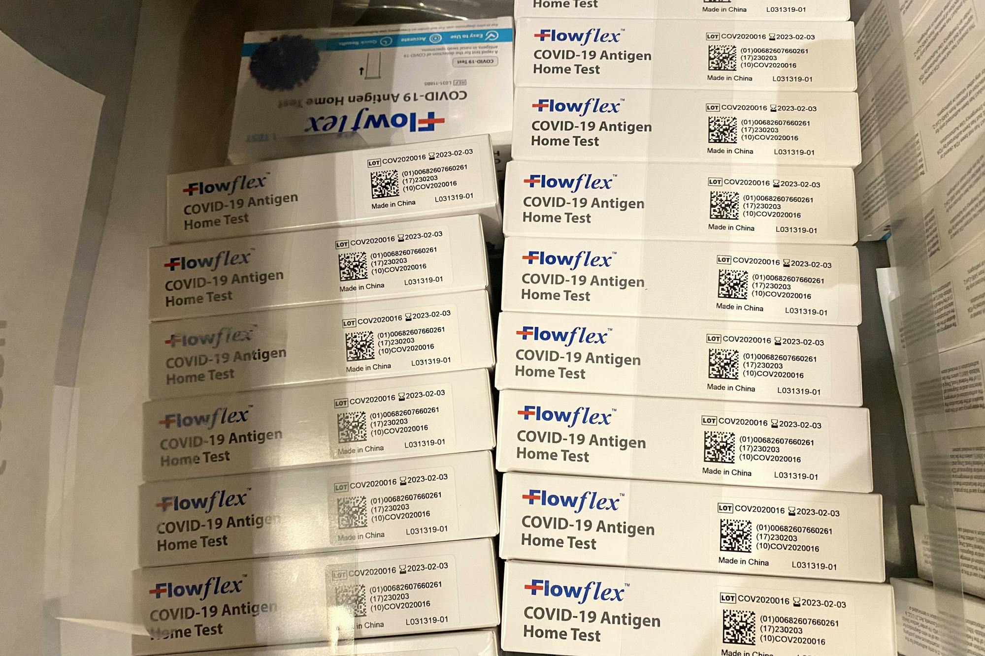 Two stacks of lateral flow COVID-19 tests.