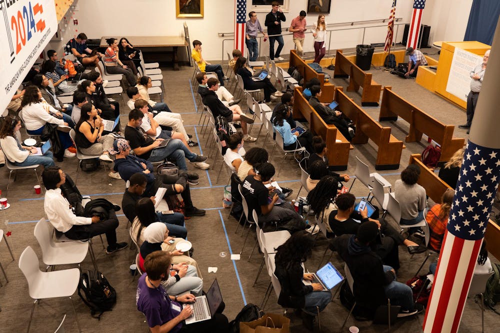 People sit in rows of gray chairs