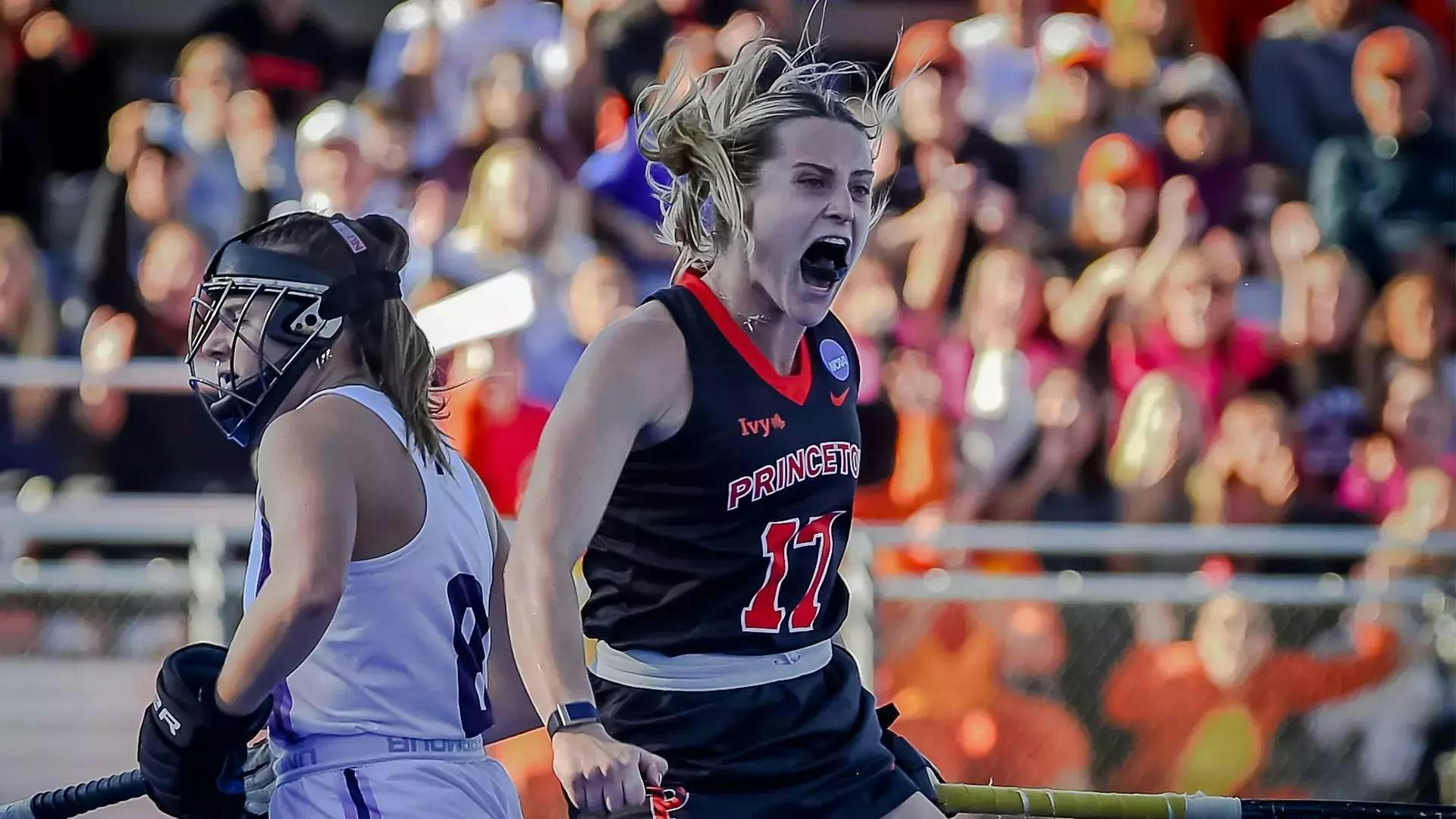 Field hockey player celebrating on pitch.