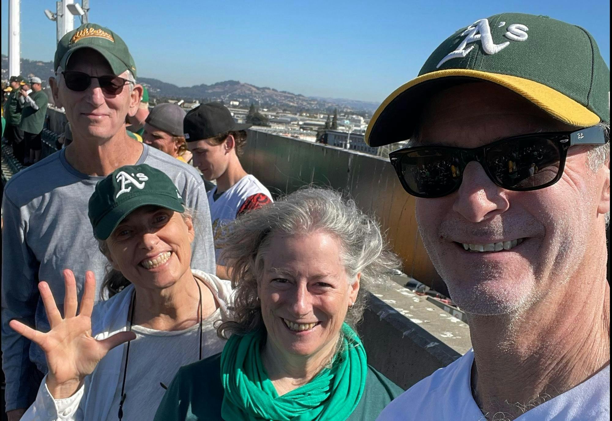 Four people smiling in front of an overview of a city