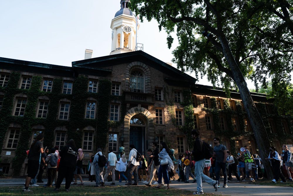 Nassau Hall — a large three-story, ivy-covered building — looms over protesters gathered on its front lawn.