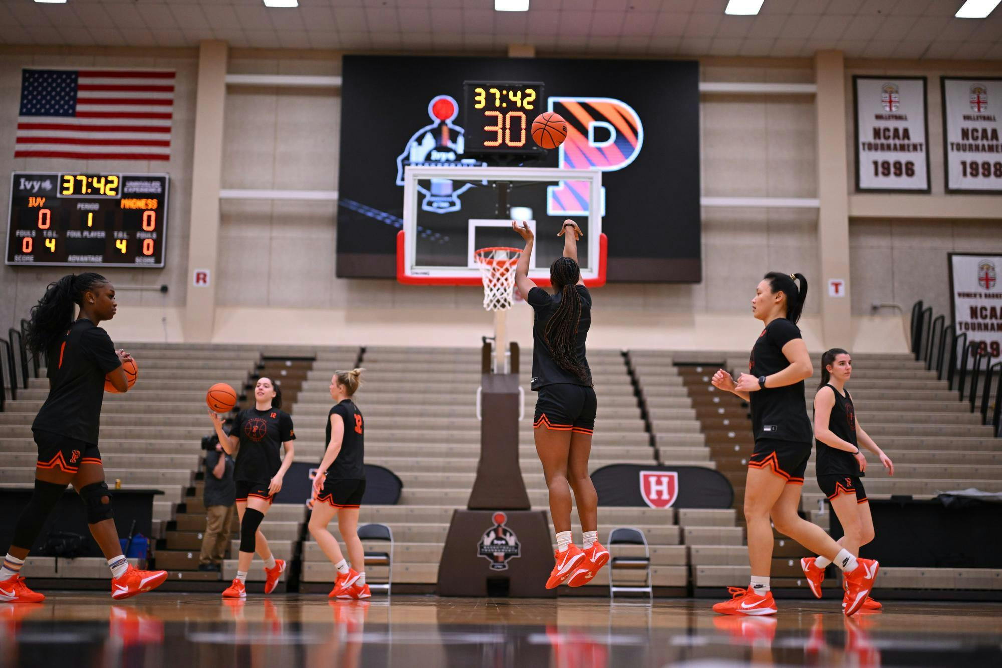 Women on a basketball team taking turns shooting shots during a shootaround.