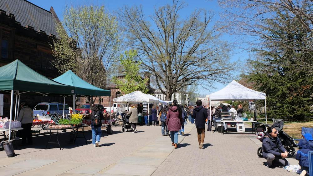 The walkway between East Pyne and Firestone is filled with walking students and food stalls. 