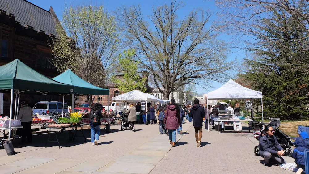 The walkway between East Pyne and Firestone is filled with walking students and food stalls.