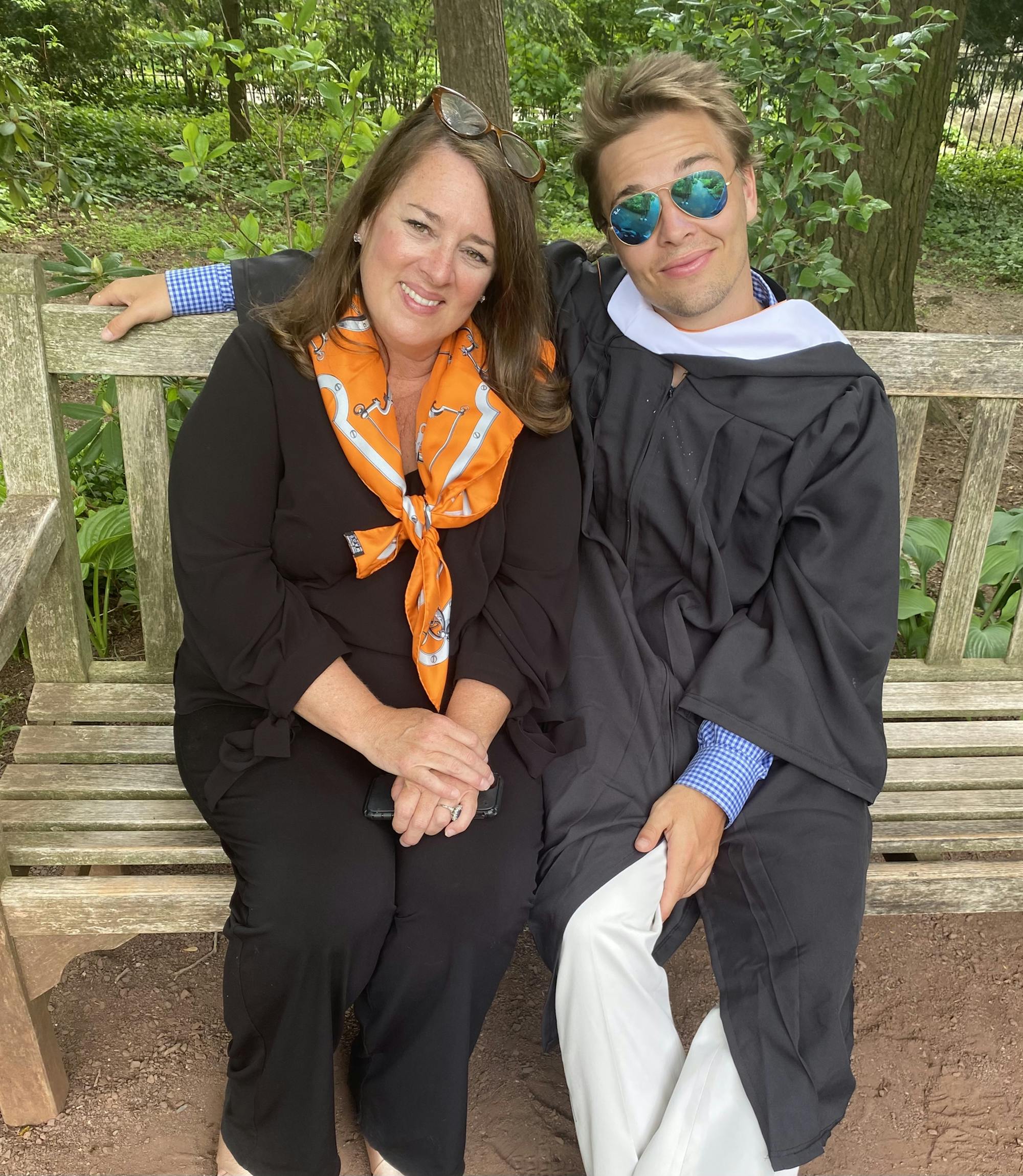 Tiger Bech is sitting next to his mother on a bench, and both face the camera.