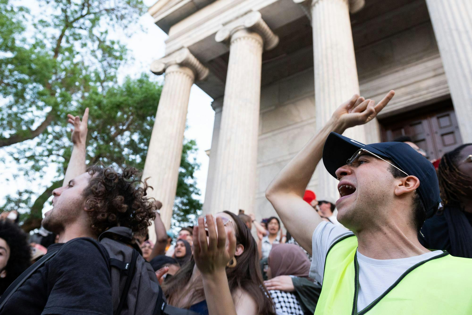 Two people shout and jump in a crowd. 