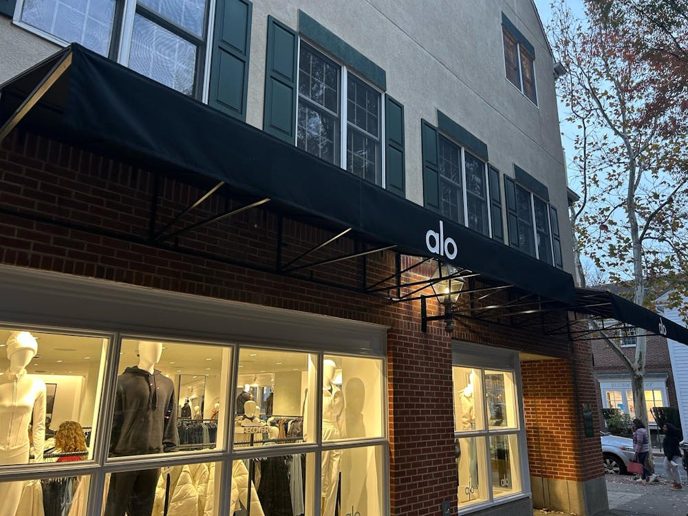 An awning covering a brightly lit storefront reads Alo.