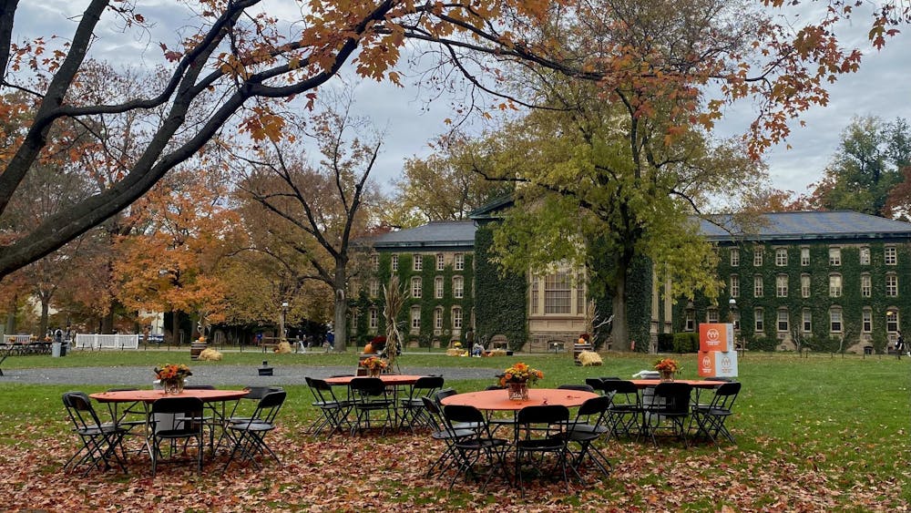 Orange tables are set up in Cannon Green with Nassau Hall in the background. 