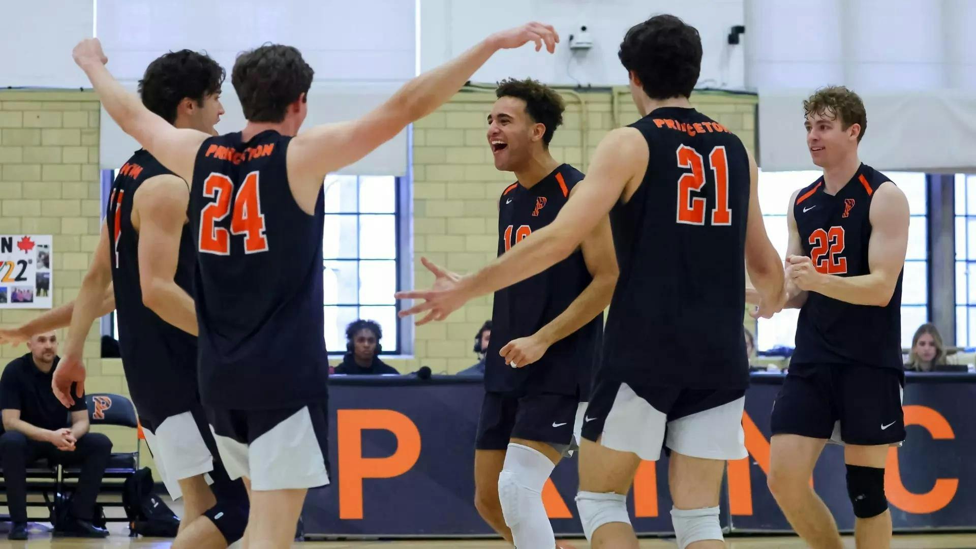 Men’s volleyball players celebrating a successful rally.