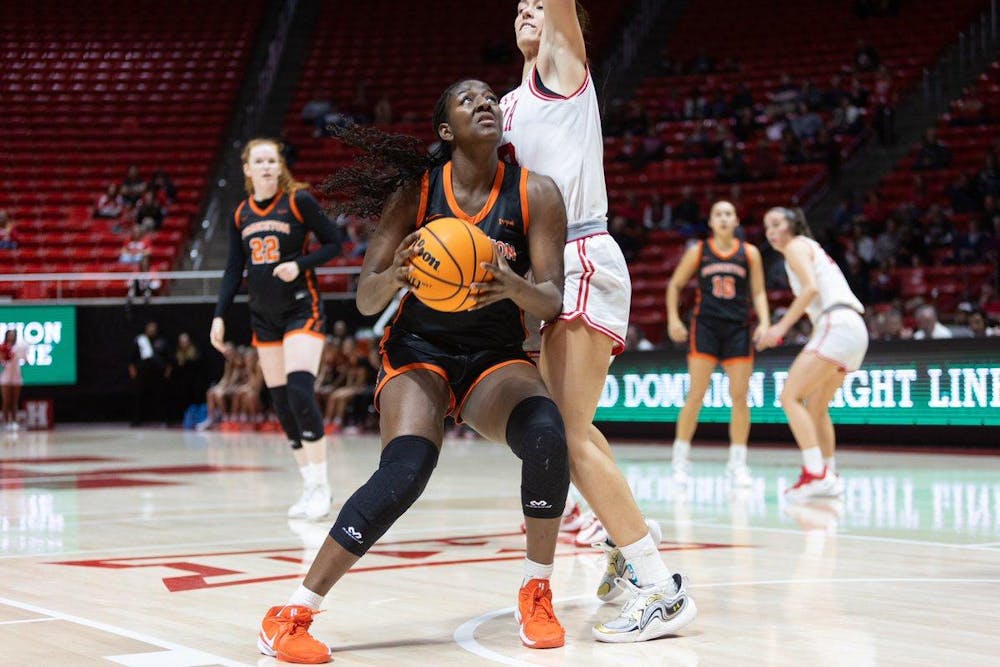 Women’s basketball player uses her body to guard the ball. 