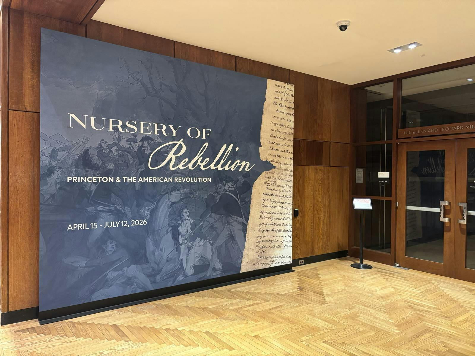 Blue poster against a brown wall in the library lobby. 