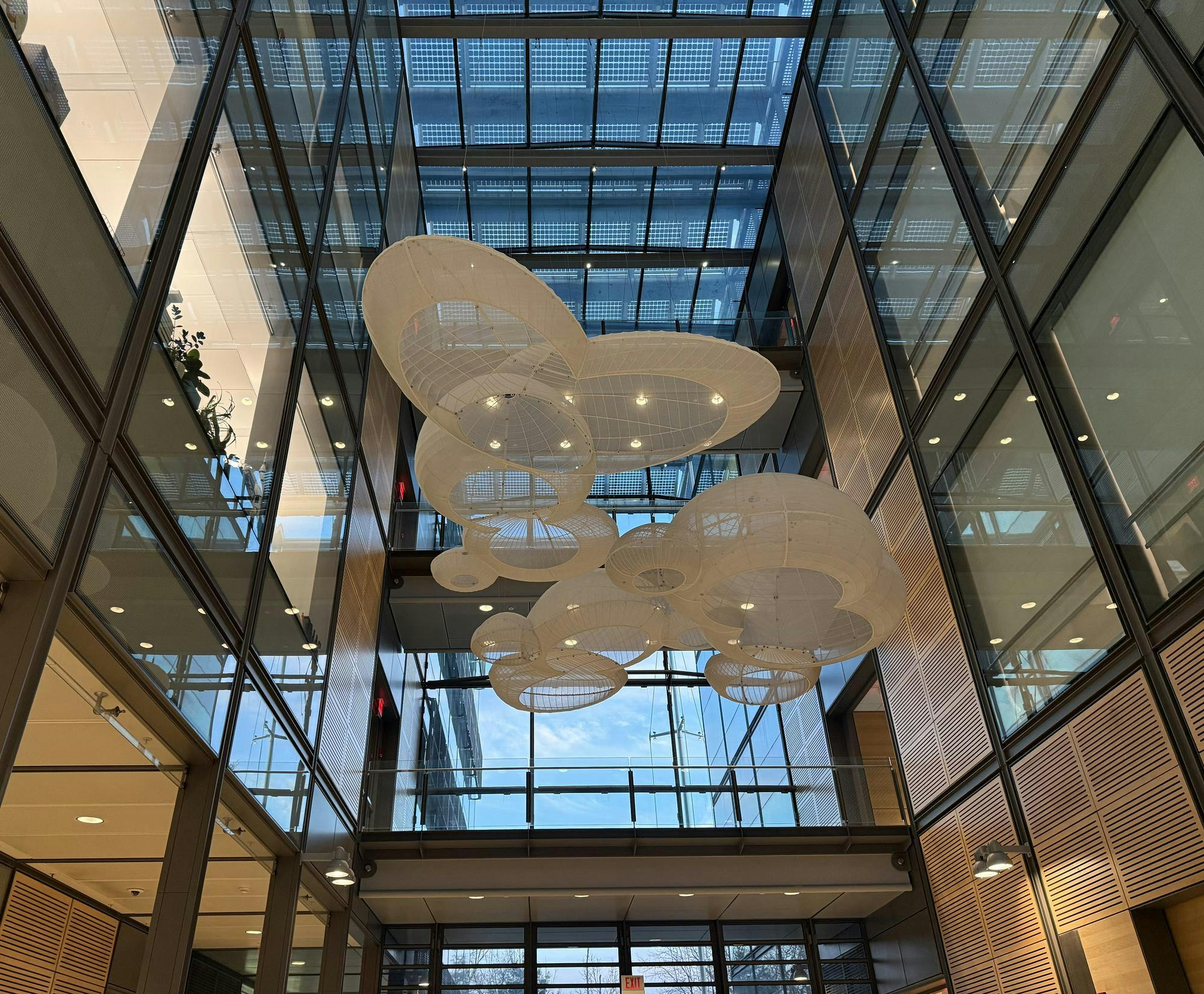 A large open building with windows on all sides. Model molecular orbitals that look like clouds are in the center of the building.