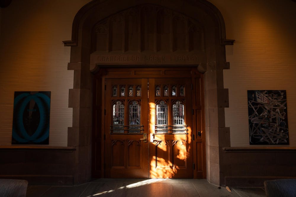 A set of brown double doors with paintings on either side