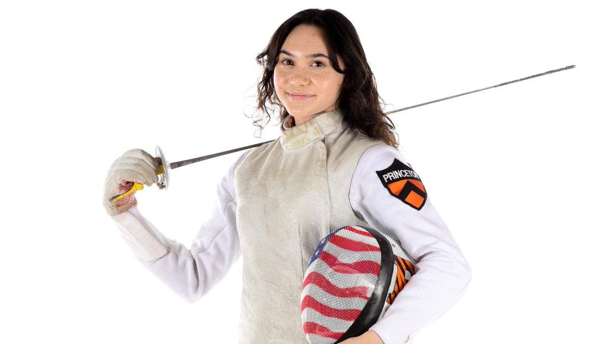 Princeton fencer poses with foil sword and USA fencing mask