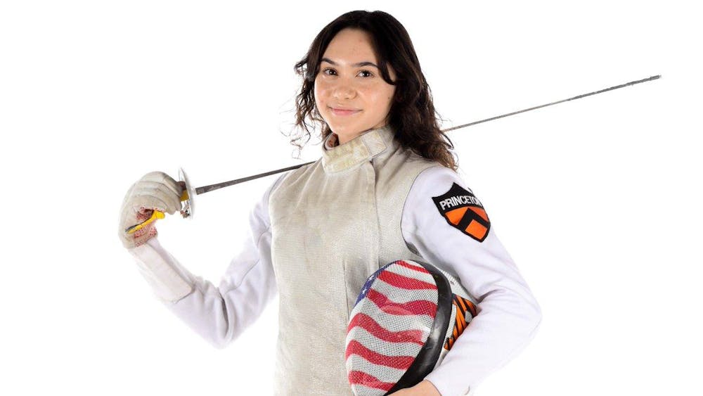 Princeton fencer poses with foil sword and USA fencing mask