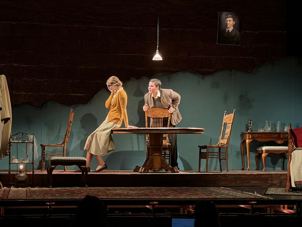 Two actors around a table. 