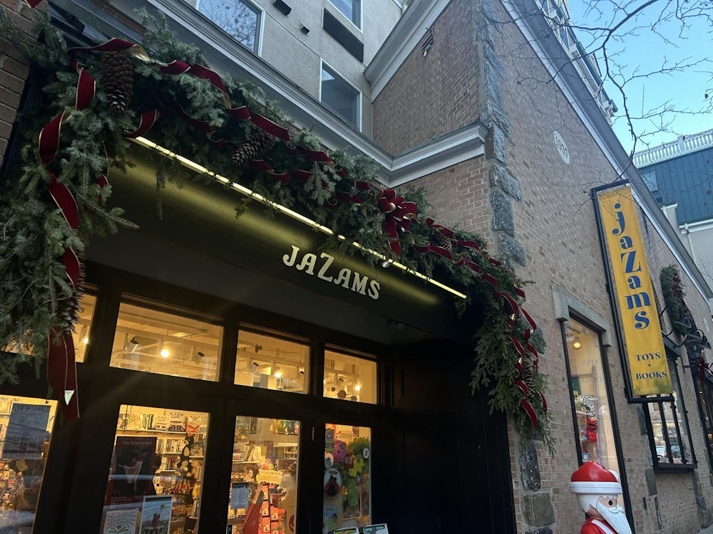 A building facade that says “JaZams” in white letters. Green garland wrapped in red ribbon stretches across the top of the facade.
