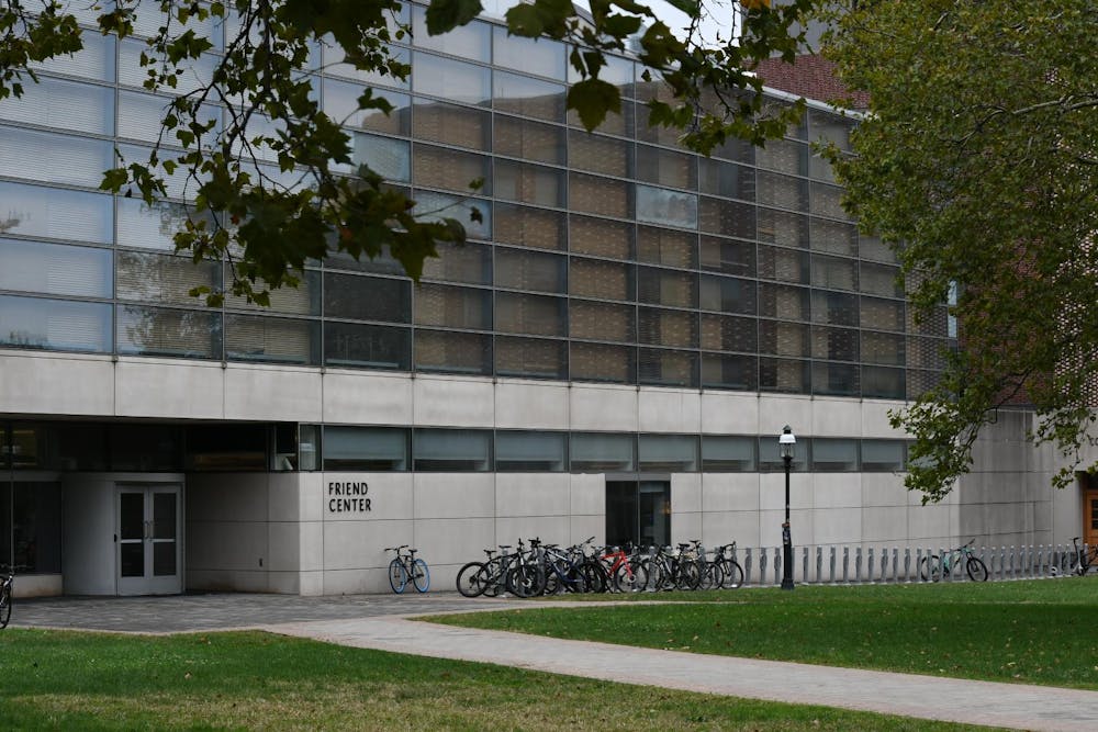 Stone building with glass windows, with bikes lined up by the door.