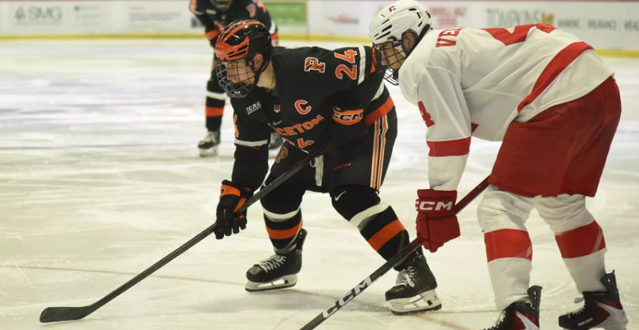 Princeton men's ice hockey player passing the puck.