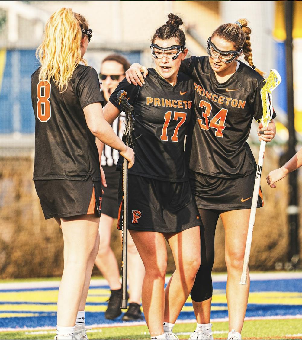 3 Women in black uniforms celebrating after a goal.