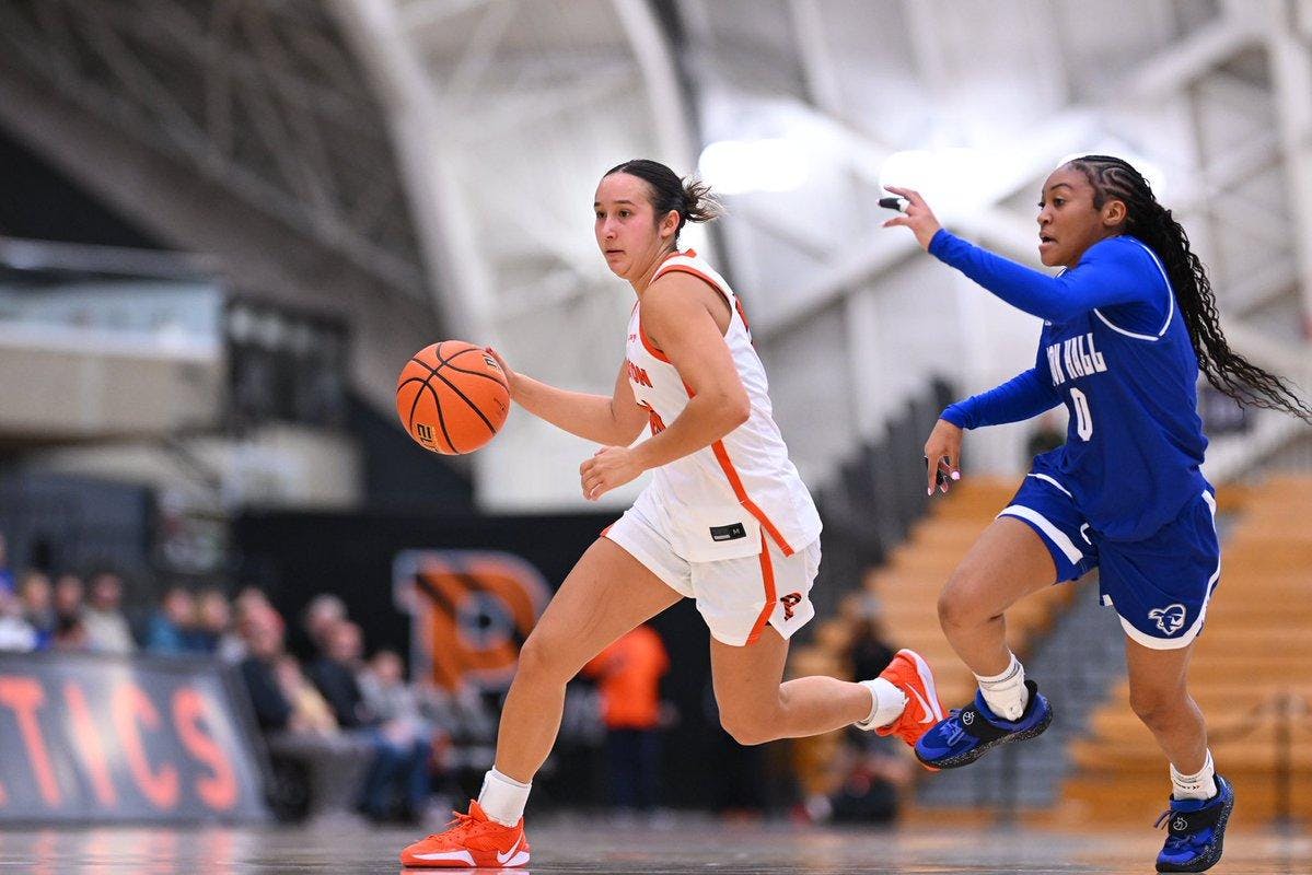 Woman running with basketball on court