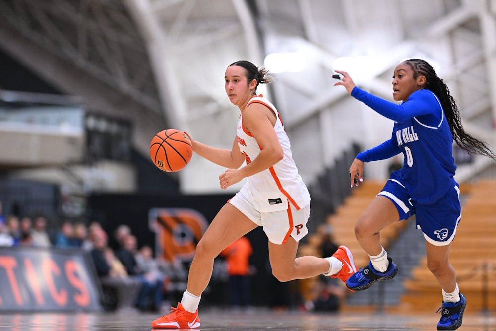 Woman running with basketball on court