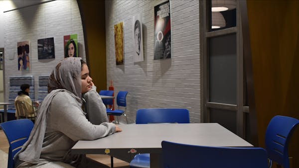 A student sits alone at a campus table, waiting and wondering if finding love in college is hard | Photo by Sarah Prosetti