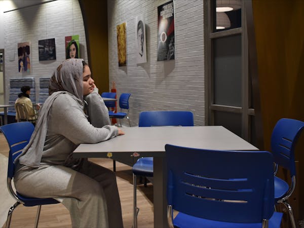 A student sits alone at a campus table, waiting and wondering if finding love in college is hard | Photo by Sarah Prosetti