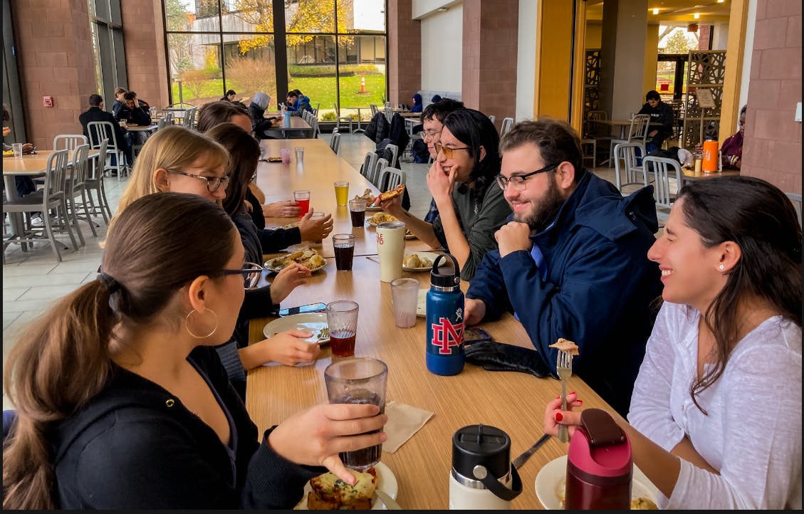 Students gather at a table for dinner | Photo by Elizabeth Denton