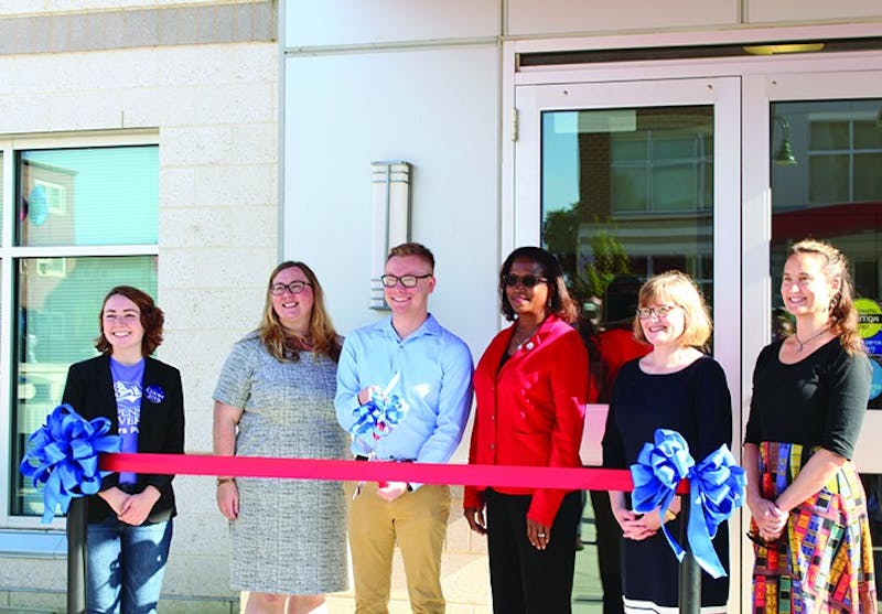 SU senior Nick Bigham (center) cuts the ceremonial ribbon of the Wood Honors College. The ceremony included sentiments about the importance of the honors college for the campus and community.