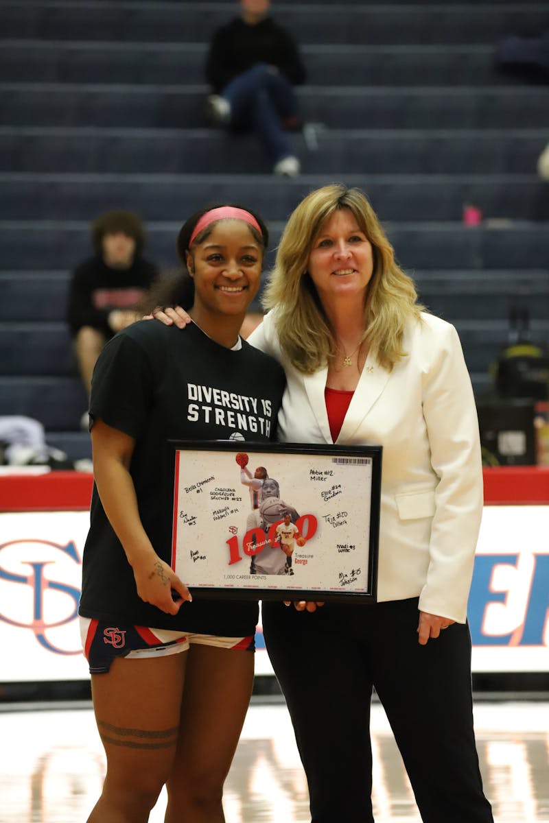 Treasure George and head coach Kristy Trn. George was honored for achieving 1,000 career points for Shippensburg University before the game.