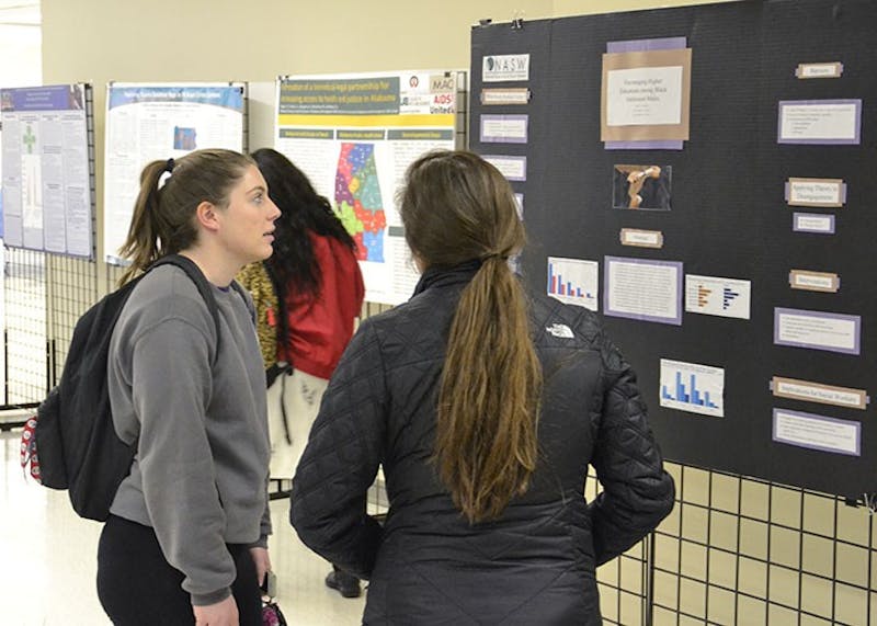 Students study the exhibits displayed during INSINC’s annual social inclusion and justice conference.
