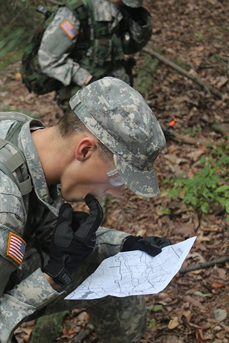 An SU ROTC cadet plans his route through the woods. Training exercises test the cadets on a wide range of mental and physical skills.