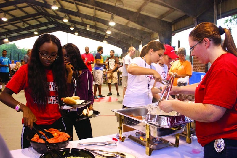 Students attend the Picnic with Police and serve themselves at the buffet inside of the SU hockey rink outside Mowrey Hall.