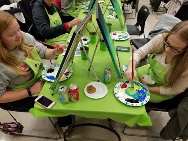 Students Kathleen Martin (left) and Keri Barth follow step-by-step instructions to complete their paintings. 