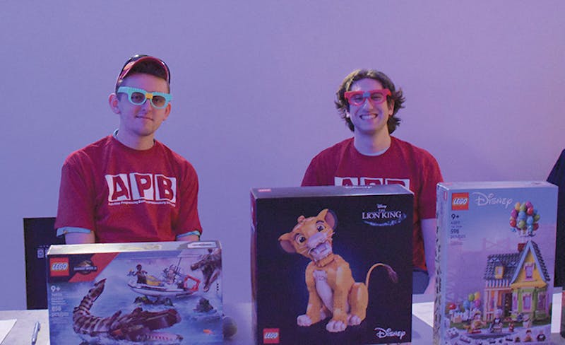Two APB members posing in front of some of the prizes at the "Legos and Eggos" event.&nbsp;