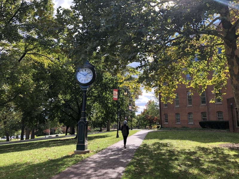 &nbsp;An SU student walks through campus on a breezy fall day. &nbsp;