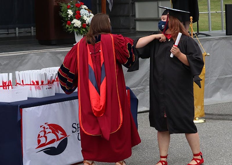 Instead of the usual hugs and handshakes, faculty and graduates shared elbow bumps.