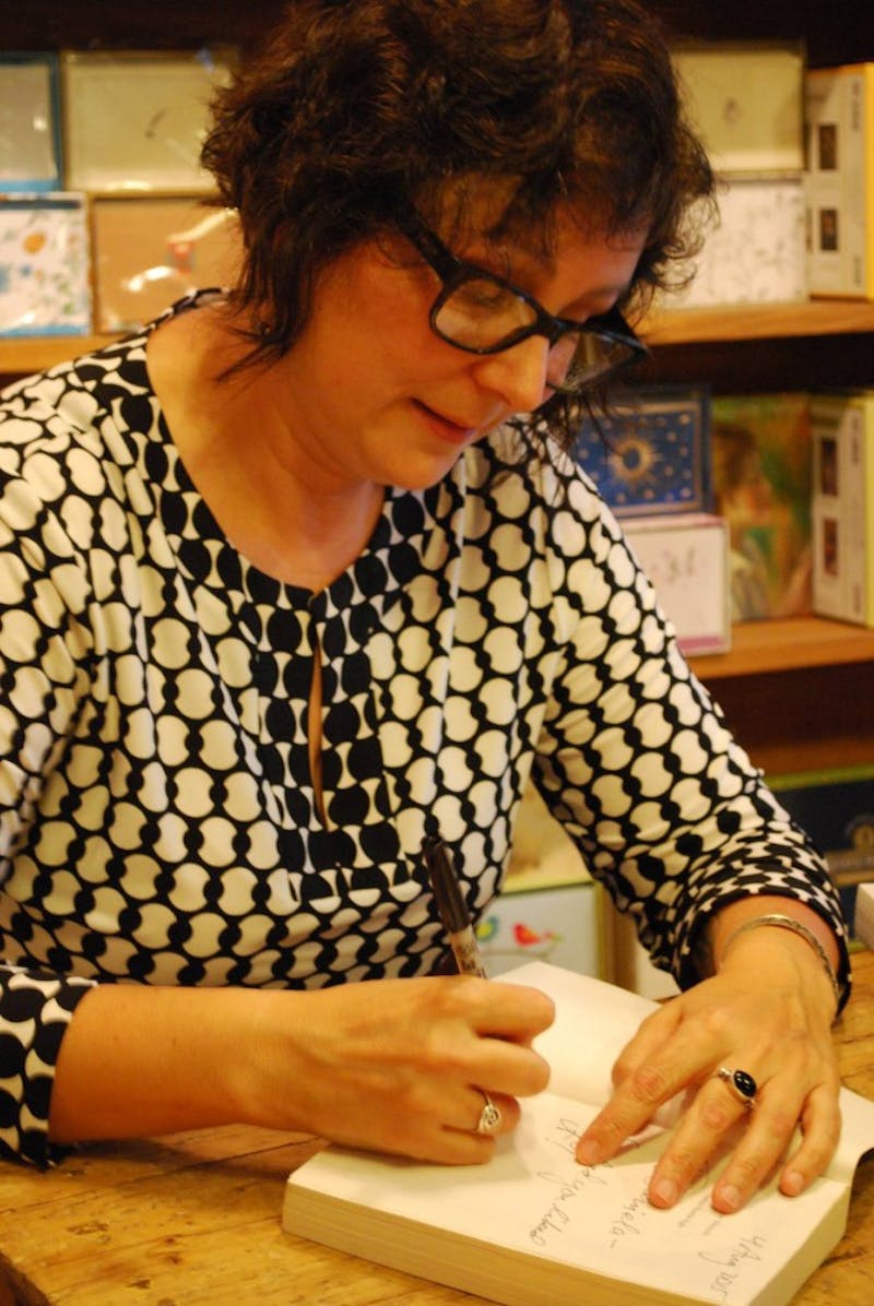 Kim van Alkemade signs a copy of her book, “Orphan #8,” which was available on the shelves on Aug. 4. Van Alkemade spent a year looking for a publisher who would contract her novel.