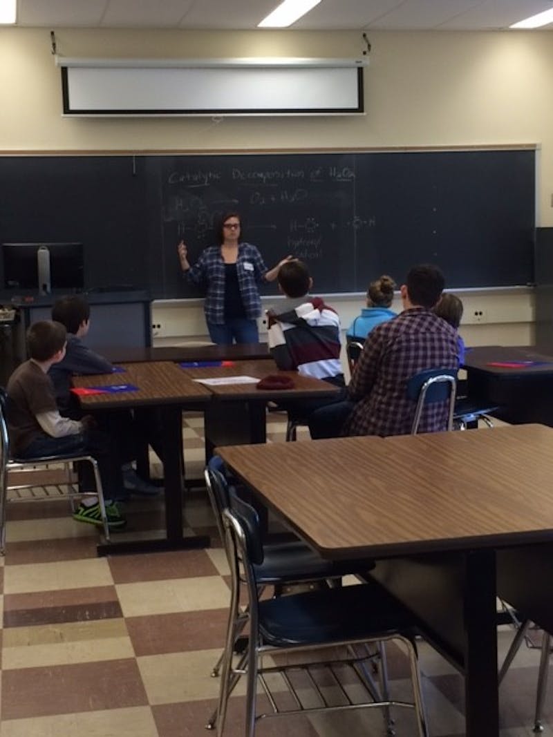 Students are attentive during a mini chemistry lesson during their trip to SU.